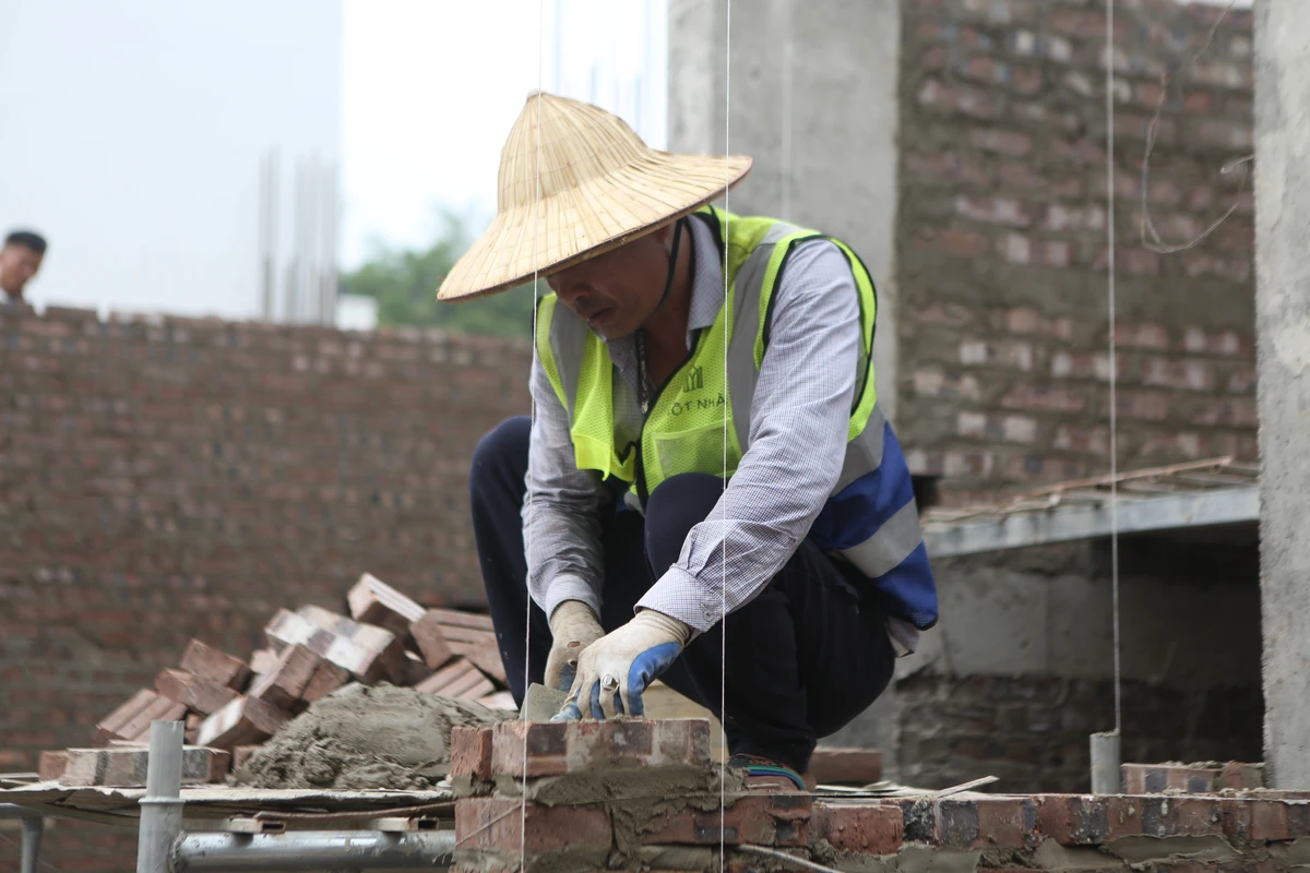Thi công phần thô – Quy trình xây tường tầng 2 tại dự án DDH đảm bảo chất lượng Thợ thi công đang cẩn thận xây tường tầng 2 tại dự án DDH.